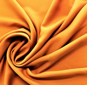 EFEKTOWNA DWUSTRONNA TKANINA KONFEKCYJNO ZASLONOWA W ORYGINALNEJ INTENSYWNIE BARWIE POMARAŃCZOWEJ W ODCIENIU SOCZYSTEJ RUDOŚCI SZEROKOŚĆ 160 CM PRODUCENT CHEMEKS PORAJ